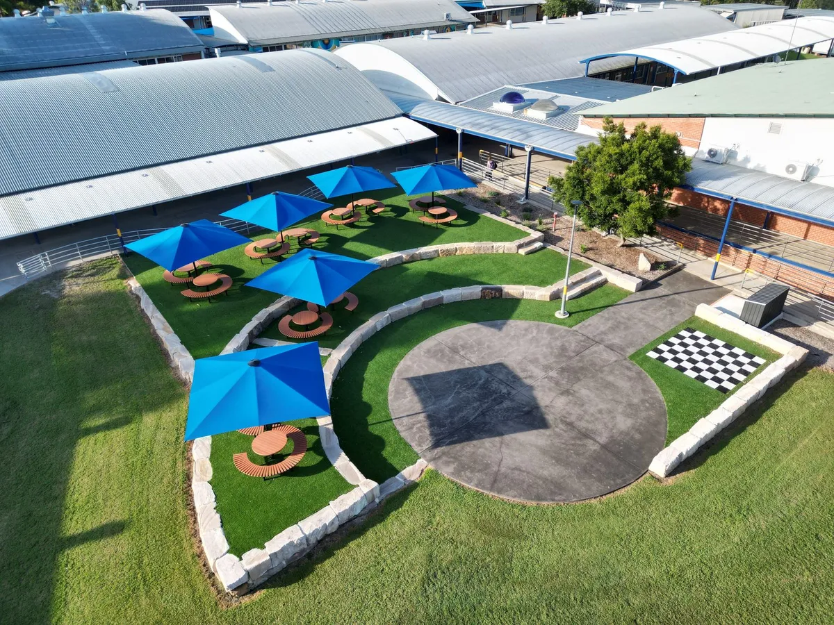 Aerial view of blue square umbrellas over curved outdoor settings at Quakers Hill High School