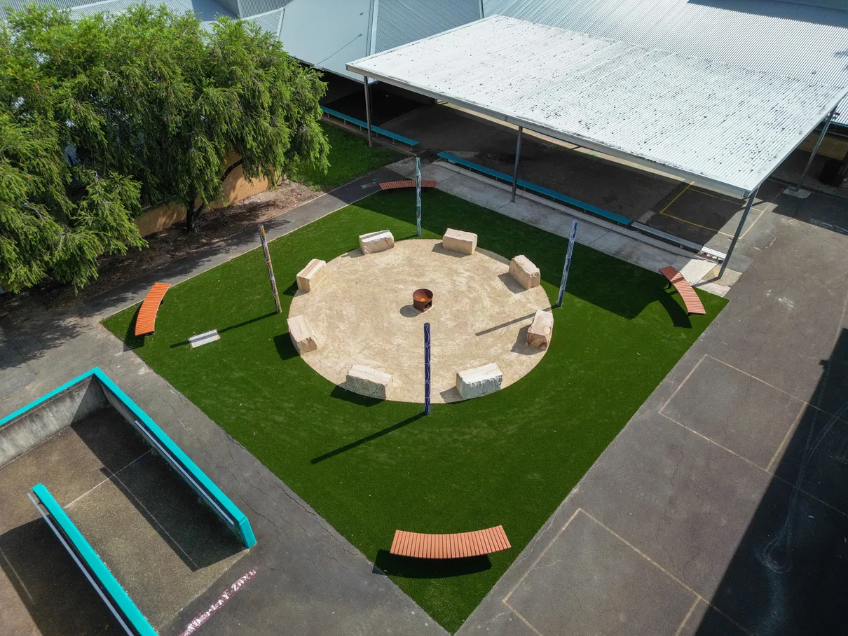 The same courtyard with a yarning circle and synthetic grass